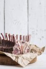 Raw rack of lamb on piece of paper — Stock Photo