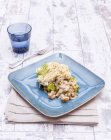 A portion of fish pie with prawns on blue plate over towel on wooden surface — Stock Photo