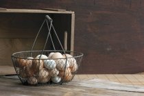 Chicken eggs in wire basket — Stock Photo