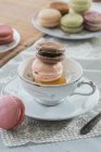 Macaroons in tea cup — Stock Photo