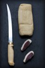 Geräucherte konservierte Entenbrust mit abgeschnittenen Scheiben neben einem Messer — Stockfoto