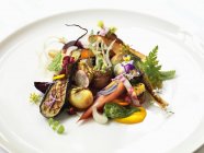 Овощи с грибами и травами на белой тарелке — стоковое фото