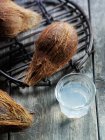 Closeup view of coconuts and water in glass — Stock Photo