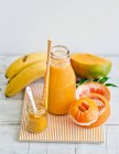 Yellow smoothie in bottle — Stock Photo
