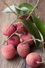 Lychees on twig with leaves — Stock Photo