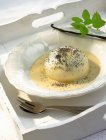 Closeup view of Dampfnudel sweet yeast dumpling with vanilla sauce and poppy seeds — Stock Photo