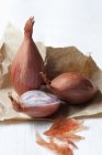 Shallots on brown paper — Stock Photo