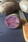 Whole and halved Purple potatoes — Stock Photo
