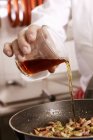 Chef adding liquid — Stock Photo
