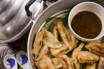 Closeup top view of Jiaotzi stuffed steamed dumplings with a dip — Stock Photo