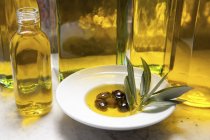 Пляшка оливкової олії та оливок — стокове фото