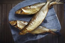 Копчена біла риба на дерев'яному табуреті — стокове фото
