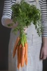 Mujer sosteniendo zanahorias - foto de stock