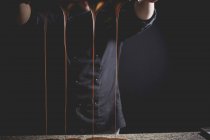 Dripping chocolate by man — Stock Photo