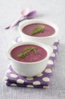 Beetroot soup in white bowls over towel — Stock Photo