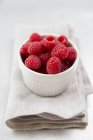 Raspberries in white bowl — Stock Photo