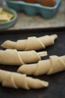 Croissants sin cocer en una bandeja para hornear - foto de stock