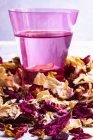 Closeup view of rose water and dried rose petals — Stock Photo