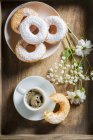 Donuts com açúcar de confeiteiro e flores — Fotografia de Stock
