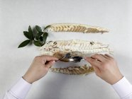 Manos masculinas fileteado pescado bajo - foto de stock