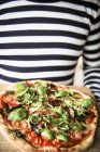 Pizza com tomates em mãos — Fotografia de Stock