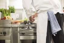 Vista traseira cortada de um chef em um fogão — Fotografia de Stock