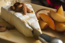 Brie with almonds on white plate — Stock Photo