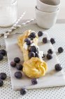 Eclair with fresh blueberries — Stock Photo