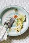 Повышенный вид на тарелку со столовыми приборами и пищевыми остатками — стоковое фото