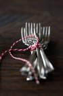 Closeup view of forks tied with string on a wooden surface — Stock Photo