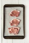 Raw pork chops on baking tray — Stock Photo