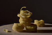 Dry uncooked tagliatelle pasta nests — Stock Photo