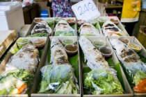 Fish with salads and sauces at market — Stock Photo