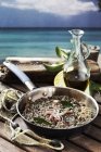 Seafood risotto with bay leaves over wooden surface — Stock Photo