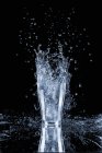 Closeup view of water glass with splash — Stock Photo