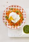 Karottenspaghetti mit pochierten Eiern und grünem Pesto auf Teller — Stockfoto
