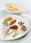 Primo piano vista di diverse erbe e spezie su un piatto e salsa — Foto stock