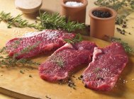Spiced raw beef steaks — Stock Photo