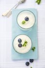 Closeup top view of vanilla cream with blueberries and mint — Stock Photo