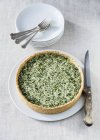 Spinach quiche on a plate with a knife  on white plate with knife — Stock Photo