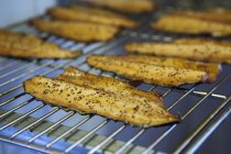 Vue rapprochée des filets de truite fumée sur une grille de cuisson — Photo de stock
