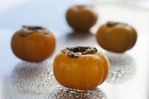 Fresh persimmons with water drops — Stock Photo