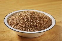 Raw bulgur in enamel bowl — Stock Photo
