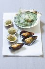 Closeup view of shellfish with gratin topping and herbs — Stock Photo