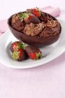 Oeuf au chocolat rempli de crème et de fraises — Photo de stock
