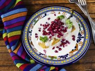 Chiles en Nogada stuffed Poblano chilli with a walnut sauce and pomegranate seeds on wooden surface — Stock Photo