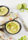 Hummus mit Chili in Schüsseln über weißer Oberfläche — Stockfoto