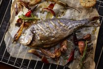 Повышенный вид морского леща с овощами на кулинарной решетке — стоковое фото
