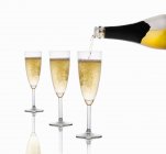 Sparkling wine being poured into glasses — Stock Photo