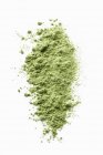 Closeup view of wheatgrass green powder on a white surface — Stock Photo